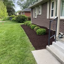 Fresh mulch defining a landscape bed beside a home